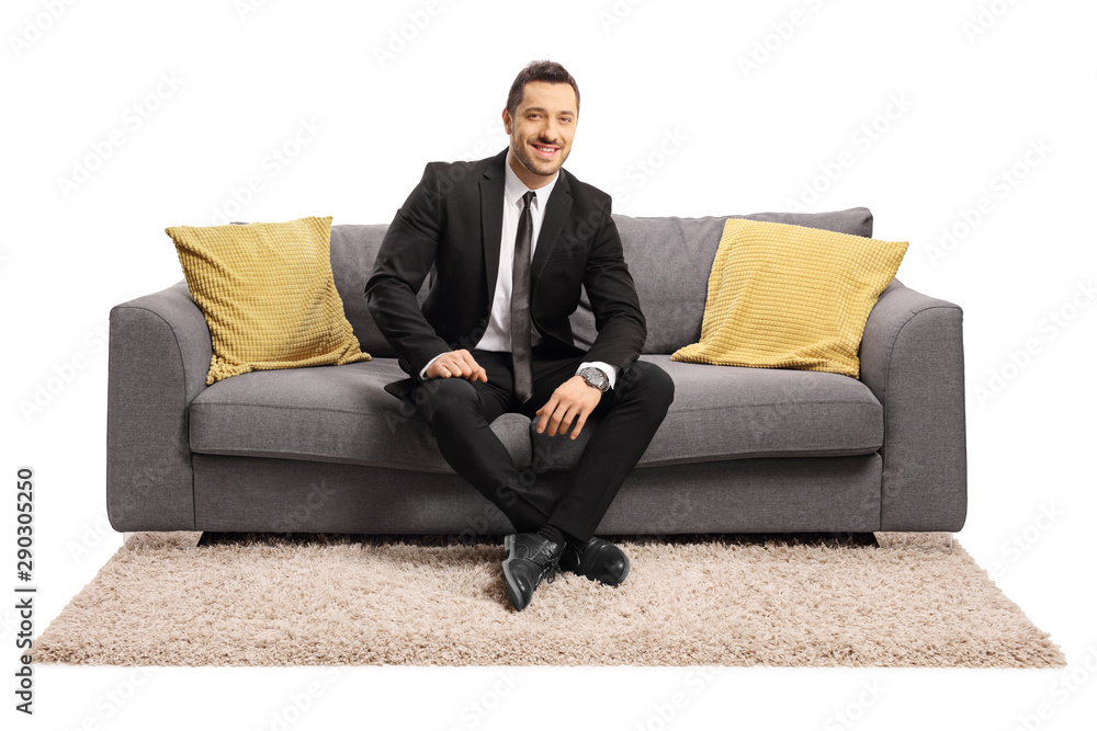 Businessman sitting on a sofa and smiling Businessman sitting on a sofa and smiling