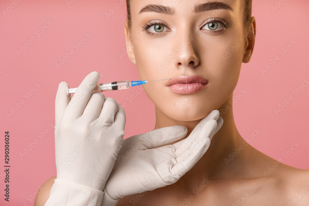 Lip augmentation. Beautiful woman receiving hyaluronic acid injection