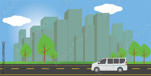 Car van ran on a road alone with a large city behind.