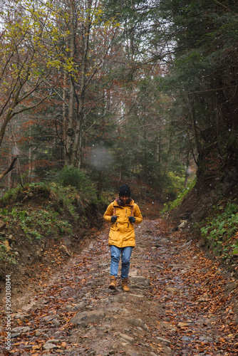 woman walking by path in forest autumn time hiking