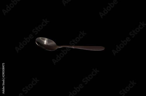 Spoon isolated on a black background © Oleksandr