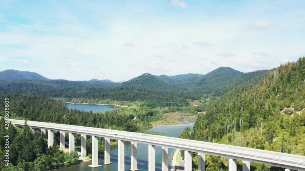 Croatia, Gorski kotar region, aerial drone shot of lake Bajer and highway bridge in town of Fuzine, panning view, cars driving over bridge Croatia, Gorski kotar region, aerial drone shot of lake Bajer and highway bridge in town of Fuzine, panning view, cars driving over bridge