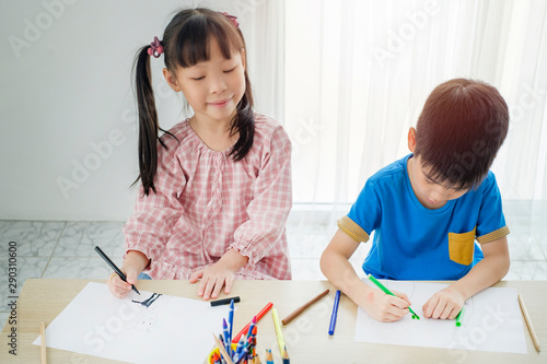 Children drawing piciture with color pencils in classroom photo