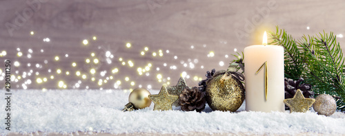 First Advent. Christmas background with Advent candle and golden decoration. photo