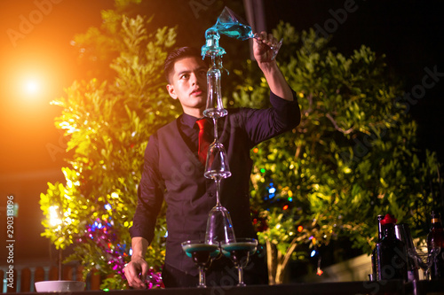 Professional bartender is making flaming lamborghini cocktail at night party.