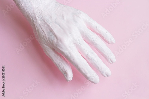 Female hand covered with paint on pink background abstract concept