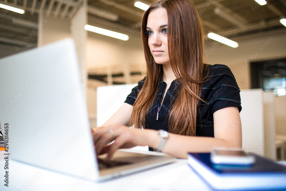 Woman skilled freelancer using applications on laptop computer, sitting in office. Female successful distance worker checking e-mail in internet via notebook. Hipster girl chatting via netbook Woman skilled freelancer using applications on laptop computer, sitting in office. Female successful distance worker checking e-mail in internet via notebook. Hipster girl chatting via netbook