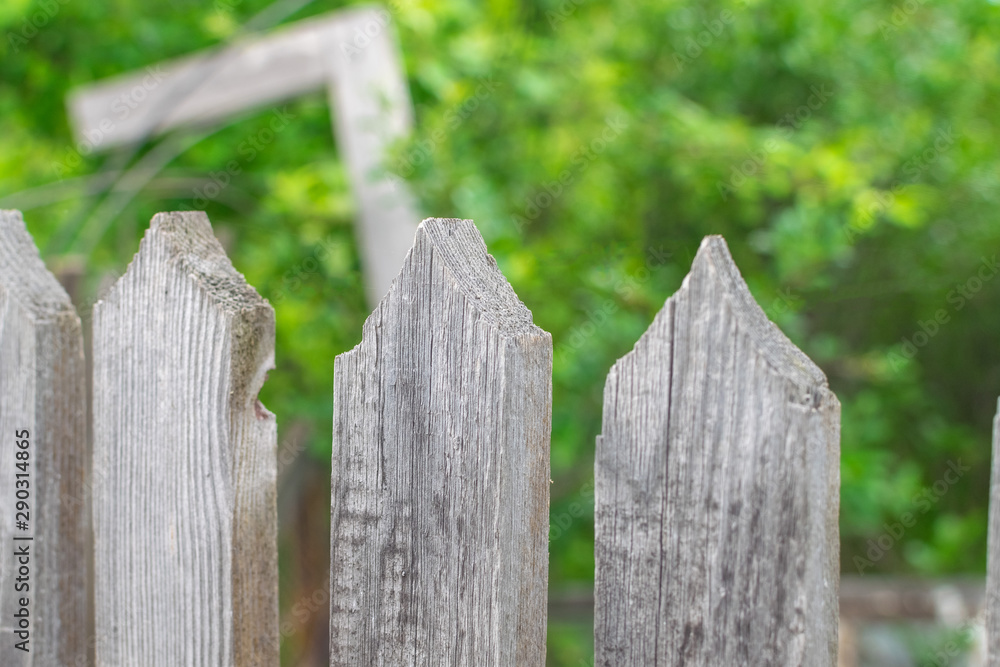 Sharp triangular tops of a wooden fence on a garden in the morning with texture wood