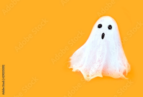 Halloween white spooky ghost spirit on orange backgrounds. Minimal concept scary autumn.