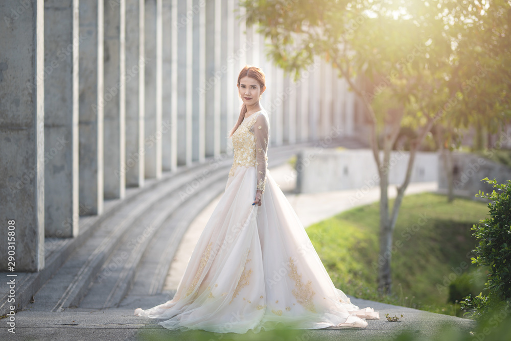 Beautiful portraits with natural light asian woman bride in wedding dress in nature meadow flower,standing in green grassy field in background. Beautiful portraits with natural light asian woman bride in wedding dress in nature meadow flower,standing in green grassy field in background.
