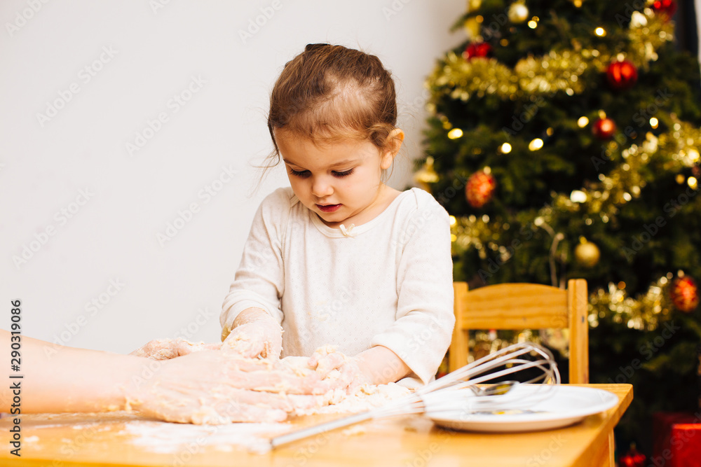Toddler girl helping knead dough for christmas cookies Toddler girl helping knead dough for christmas cookies