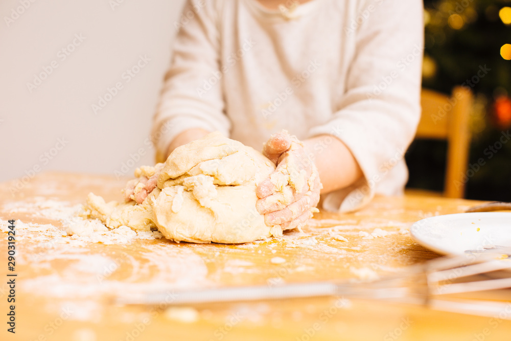 Toddler girl hands kneading and shaping dough