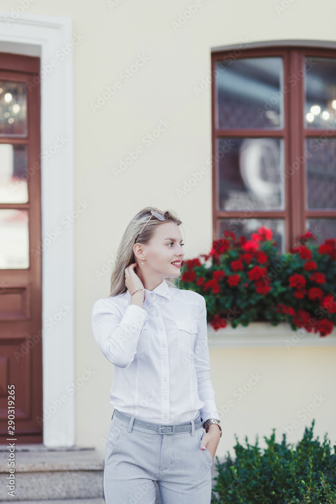 beautiful blonde woman in pants posing in business clothes