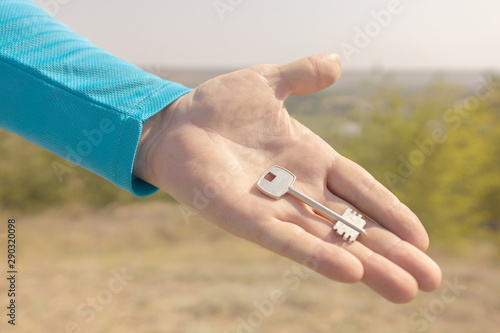 Hand holding keys on blur landscape background