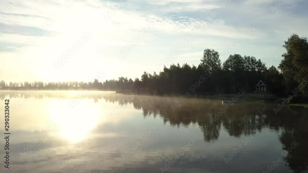 Nice aerial video of Sweden landscape - drone flies quite low above calm lake surface, close to coastline through foggy morning air and then to more sunny place, Swedish countryside landscape below Nice aerial video of Sweden landscape - drone flies quite low above calm lake surface, close to coastline through foggy morning air and then to more sunny place, Swedish countryside landscape below