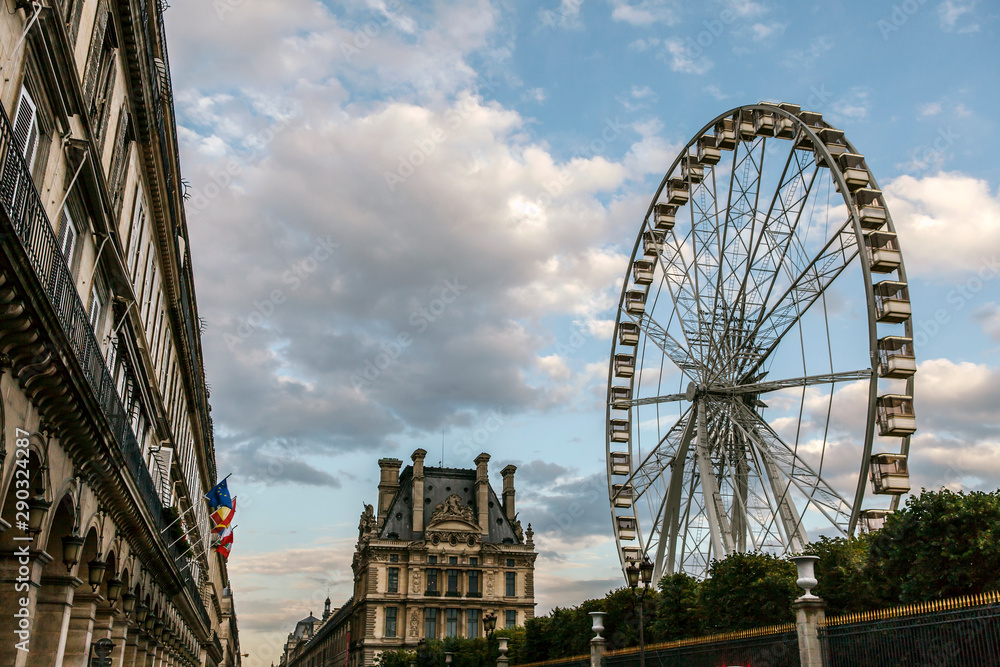 Ferris wheel and architecture of Paris with blue sky background at Jardin Des Tuileries in Paris. Ferris wheel and architecture of Paris with blue sky background at Jardin Des Tuileries in Paris.