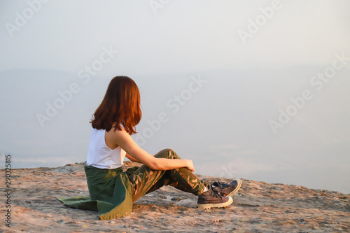 A beautiful broken heart women is traveling alone and feel down on the top of the mountain.