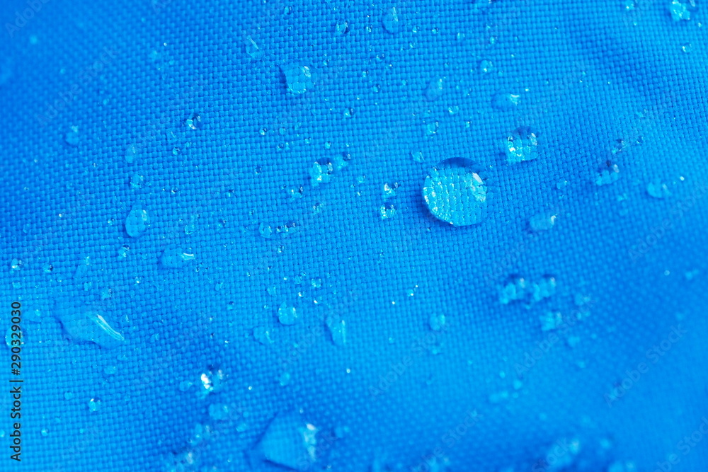Φωτογραφία Closeup of water drops on bright blue fabric with waterproof design to protect fabric of the cloth from humidity and to offer easy cleaning to users