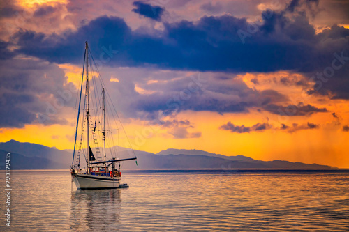 Natural background with Yacht in the Mediterranean sea at sunrise, Cagliari, Italy. he sun illuminates the island with beautiful golden colors