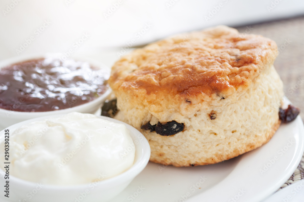 Homemade fresh baked scone with cream and straberry jam on rattan mat. Homemade fresh baked scone with cream and straberry jam on rattan mat.