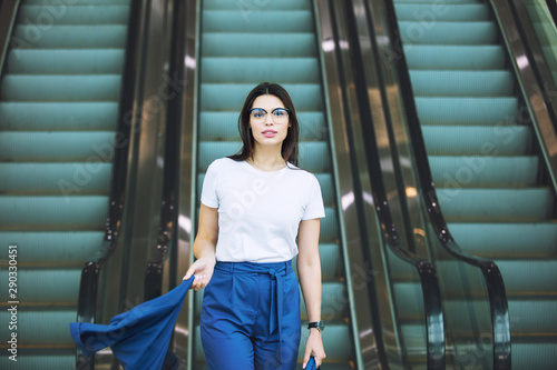 Young adult beautiful brunette girl happy businesswoman on escalator in business center