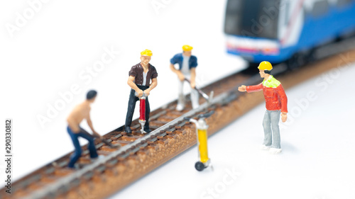 Selective focus miniature people team repair train tracks, The foreman ordered the railway repairman.