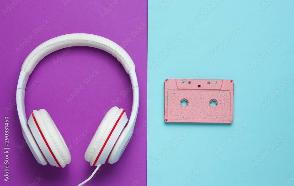 Audio cassette and headphones on purple blue background. Retro music concept. Vintage background. Disco party. Top view Audio cassette and headphones on purple blue background. Retro music concept. Vintage background. Disco party. Top view