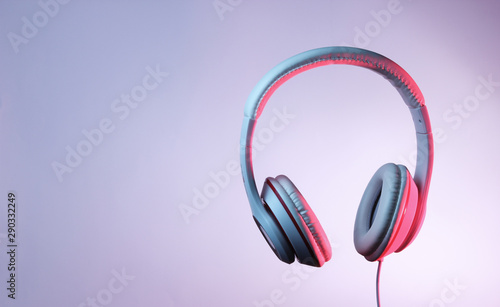 Classic wired headphones with gradient blue pink neon light. Retro style.Retro wave. 80s. Minimalistic music concept.