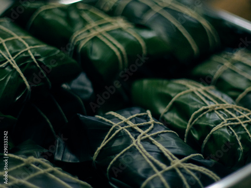 you can see the hallacas inside their banana leaf wrap, stacked in trays photo