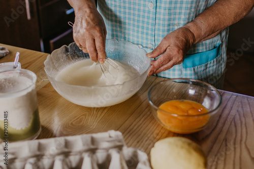 adult woman in the kitchen kneading the mix for sweets and desserts