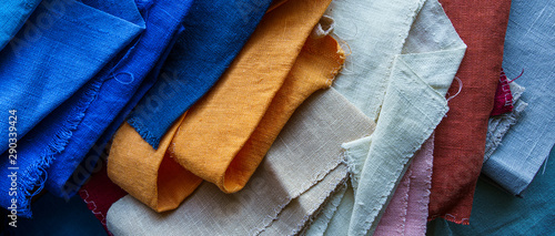 A stack of colorful fabrics background. Multicolored linen fabric photo