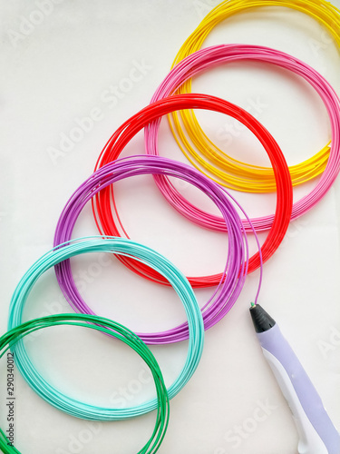 colorful rubber bands isolated on white background. Contemporary art and technology. 3D pen and 6 skeins of colored plastic for it. Ideas for creativity.