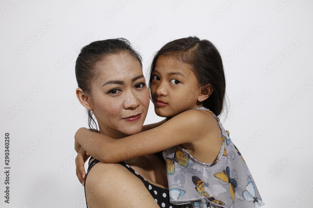 Beautiful asian mother smiles with her daughter in arms Beautiful asian mother smiles with her daughter in arms