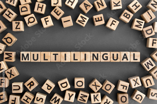 multilingual - word from wooden blocks with letters, use many  different languages multilingual concept, random letters around, grey background