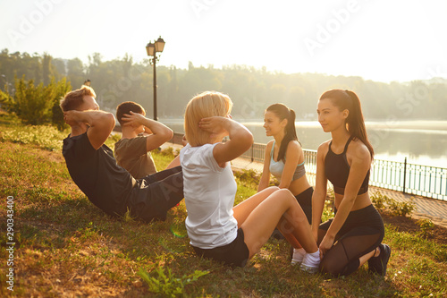 A group of people doing exercises sitting in the park
