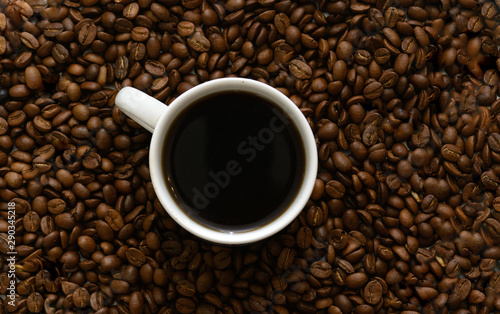 In coffee beans there is a white cup with coffee. Concept - morning coffee. Pleasure.