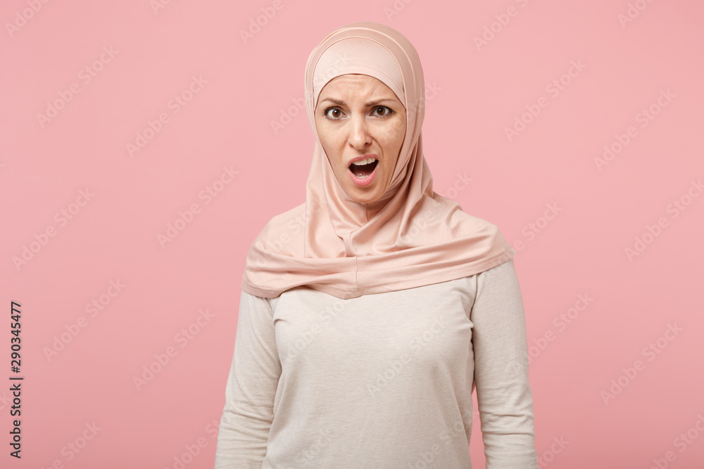 Shocked irritated young arabian muslim woman in hijab light clothes posing isolated on pink background, studio portrait. People religious Islam lifestyle concept. Mock up copy space. Looking camera. Shocked irritated young arabian muslim woman in hijab light clothes posing isolated on pink background, studio portrait. People religious Islam lifestyle concept. Mock up copy space. Looking camera.