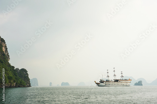 A tourist vessel in the karst landscape of Ha Long Bay, Quang Ninh Province, Vietnam. Ha Long Bay is a UNESCO World Heritage Site.