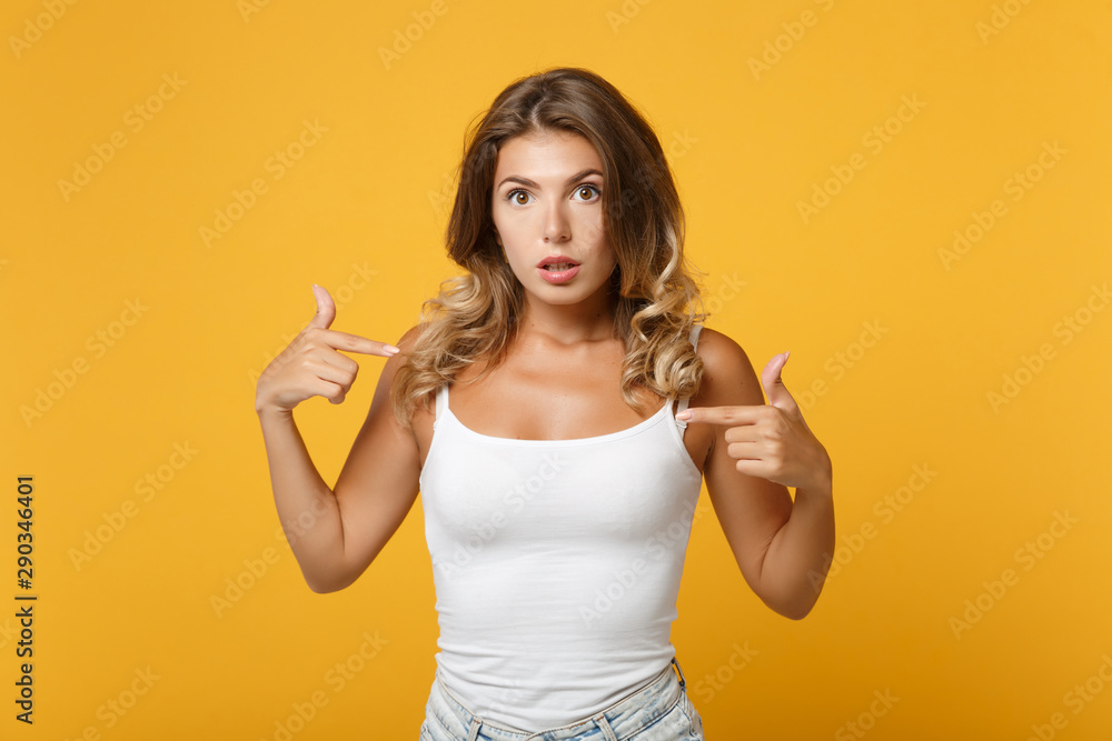 Perplexed young woman in light casual clothes posing isolated on yellow orange background in studio. People sincere emotions lifestyle concept. Mock up copy space. Pointing index fingers on herself. Perplexed young woman in light casual clothes posing isolated on yellow orange background in studio. People sincere emotions lifestyle concept. Mock up copy space. Pointing index fingers on herself.