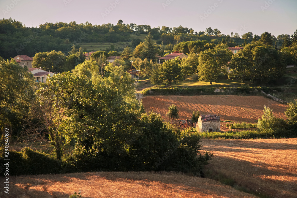 Agricultural fields at sunset, countryside landscape in the south of France at sunny summer evening