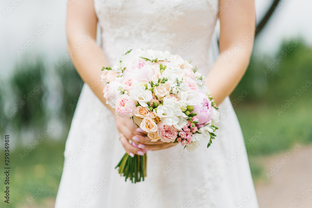 beautiful delicate wedding bouquet in the hands of the bride of roses, freesia, peonies, roses David Austin beautiful delicate wedding bouquet in the hands of the bride of roses, freesia, peonies, roses David Austin