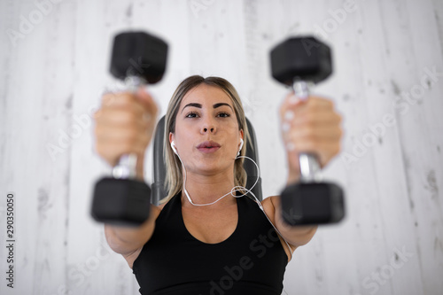 Beautiful young attractive woman is working out in the gym © Milana