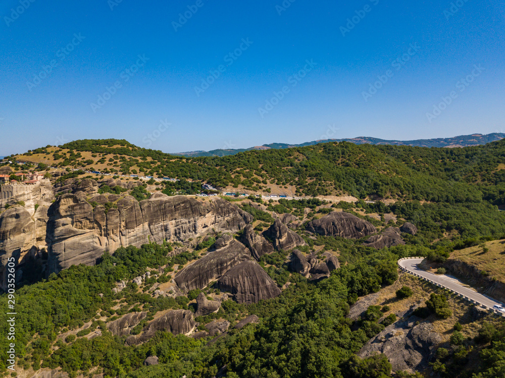 Aerial view of a mountain range. View of the cliffs of Meteora and the monasteries of Meteora. Many ancient Orthodox monasteries summer. Photo from drone. Kalampaka town, Greece.