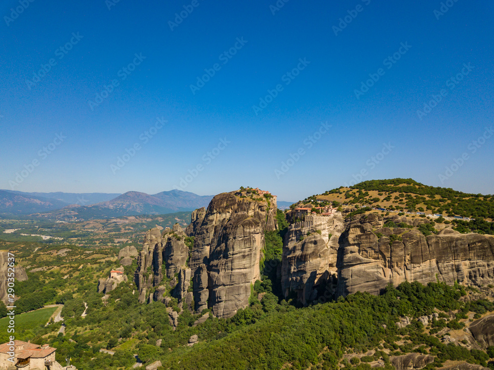Aerial view of a mountain range. View of the cliffs of Meteora and the monasteries of Meteora. Many ancient Orthodox monasteries summer. Photo from drone. Kalampaka town, Greece. Aerial view of a mountain range. View of the cliffs of Meteora and the monasteries of Meteora. Many ancient Orthodox monasteries summer. Photo from drone. Kalampaka town, Greece.