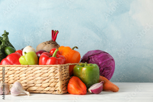 Fototapeta Naklejka Na Ścianę i Meble -  Wicker basket and vegetables on white wooden background, copy space