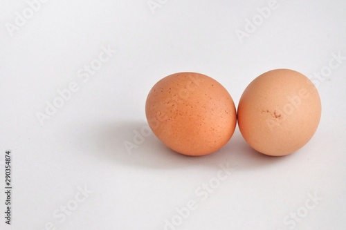 A pair of raw eggs on grey background and copy space