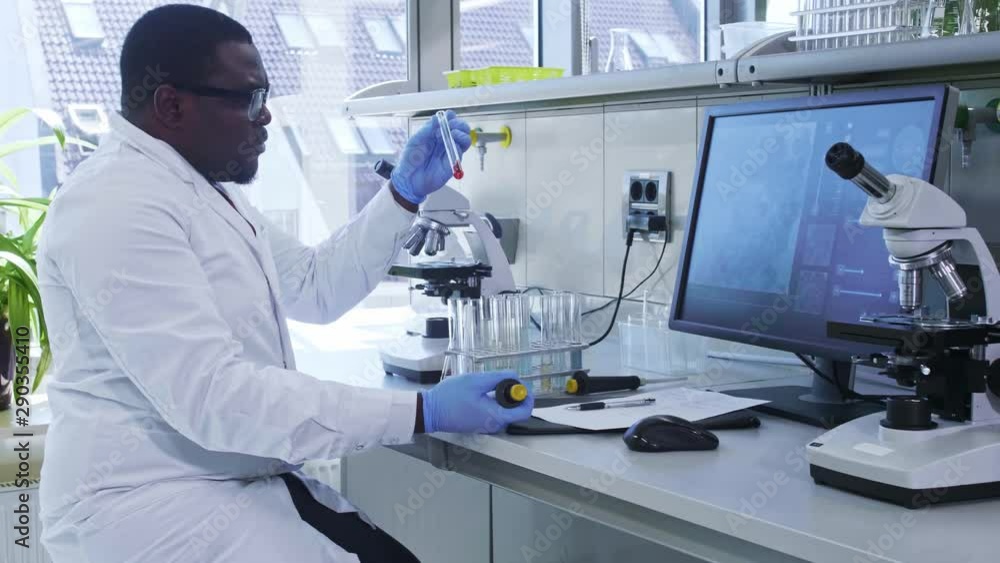 African-american scientist working in lab. Male doctor making microbiology research. Biotechnology, chemistry, bacteriology, virology, dna and health care. African-american scientist working in lab. Male doctor making microbiology research. Biotechnology, chemistry, bacteriology, virology, dna and health care.