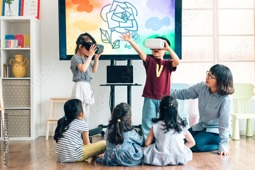 Preshool kids wearing virtual reality headset in classroom photo