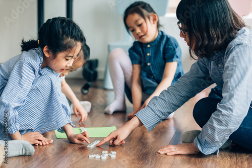 Teacher and preschool kids learning  in classroom photo