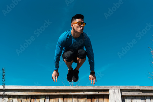 Young asian man practicing parkour in the city. photo